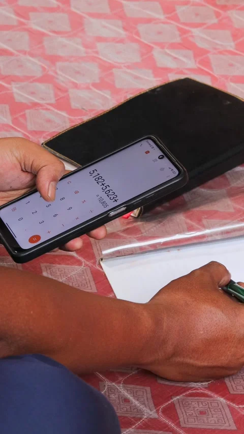 Man using a calculator app on a smartphone for financial management Stock Footage 336295075