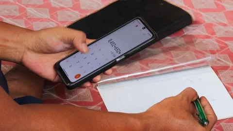Man using a calculator app on a smartphone for financial management Stock Footage 336295101
