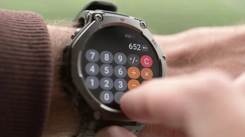 Man using calculator application on rugged smartwatch close up Stock Footage 347889692