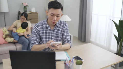 Man using a calculator is telling his wife Stock Footage 149075178