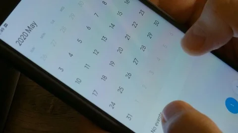 Man using calendar app on the mobile device. Male hands scrolling on smartphone. Stock Footage 126774176