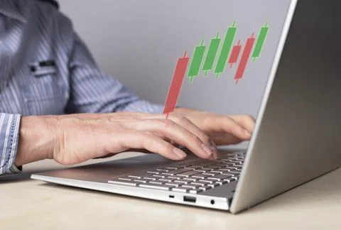 Man using candlestick graph for tracking price movement. Trader hands at laptop Stock Photos