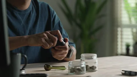 Man using cannabis grinder Stock Footage 333179423