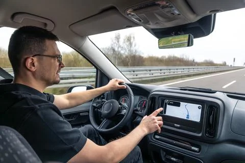 Man Using Car Navigation Screen While Driving On Highway Fotos de archivo