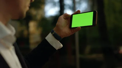 Man using cel phone with green screen for internet surfing online. Close up Stock Footage 131597332