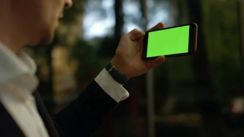 Man using cel phone with green screen for internet surfing online. Close up Video stock 141256906