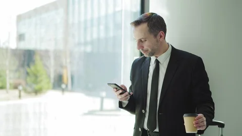 Man using cell phone and drinking coffee in airport Stock Footage 108681210