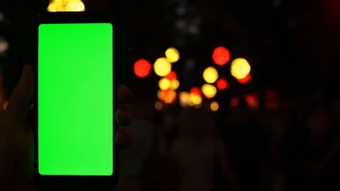 Man using cell phone chinatown holding greenscreen chromakey at evening bokeh Stock Footage 95839074