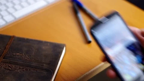 A man using a cell phone at his desk. Stock Footage 76784579