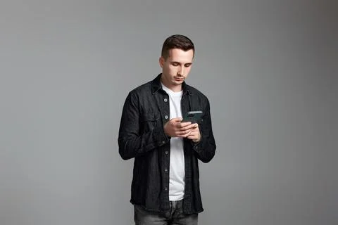 Man using cell phone isolated on gray background. 写真素材