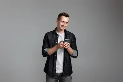 Man using cell phone isolated on gray background. 写真素材