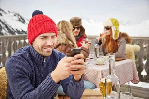 Man using cell phone on snowy balcony 写真素材