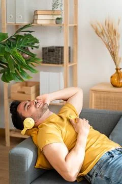 Man using cell phone while relaxing at home. Stock Photos
