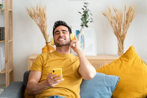 Man using cell phone while relaxing at home. Stock Photos