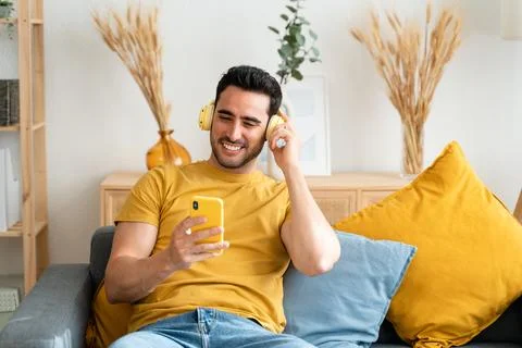 Man using cell phone while relaxing at home. Stock Photos