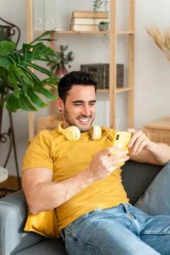 Man using cell phone while relaxing at home. Stock Photos