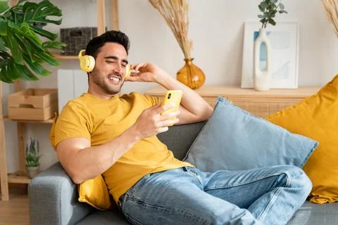 Man using cell phone while relaxing at home. Stock Photos