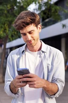 Man using cell phone while walking down the street Stock Photos