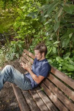 Man using a cellphone in the park Stock Photos