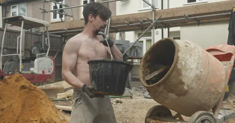 Man using a cement mixer on a building site Stock Footage 246382182