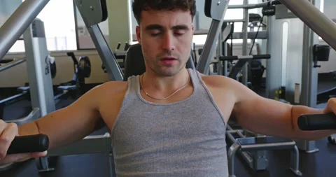 Man Using Chest Press Machine at Gym Stock Footage 323775940