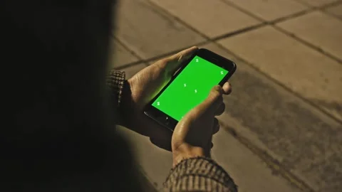 Man using Chroma Key Smartphone while Standing, Gesturing, Swiping, Scrolling Stock Footage 155798604