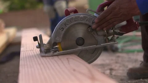 Man using a circular saw to cut through wood Stock Footage 137971854