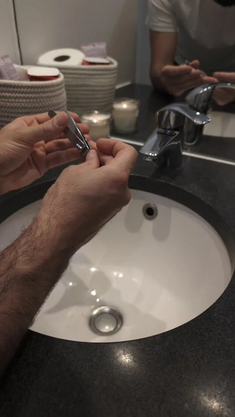 Man using clipper in bathroom for morning grooming, trimming fingernails Video stock 335637478