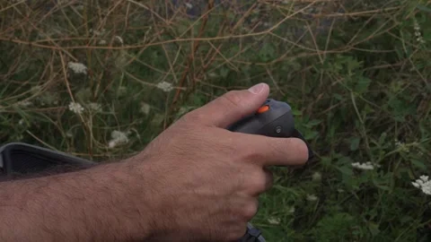 Man using a compact remote controller to operate a drone Stock Footage 345176772