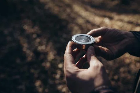 Man using compass in forest Stock Photos