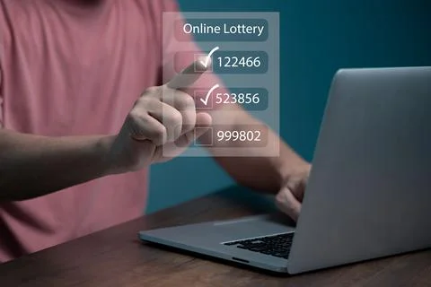 Man using computer and touching on virtual Online lottery screen to buy two n Stock Photos