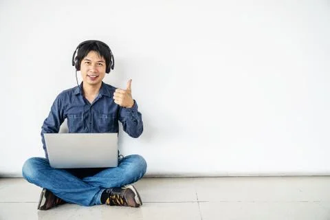 Man using computer laptop listening nice music is happy with smile doing ok sign Stock Photos