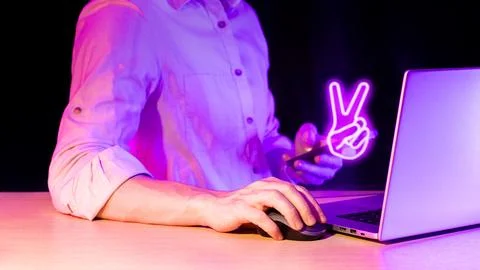 Man using computer mouse with holographic purple peace sign over phone Stock Photos