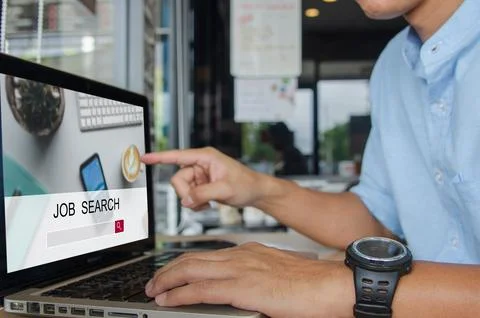 Man using a computer to search for jobs. Stock Photos