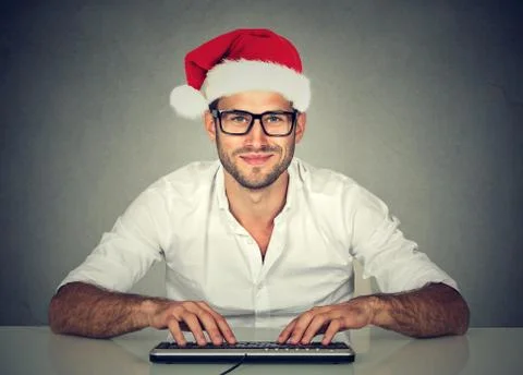 Man using computer shopping online looking for a christmas gift. Stock Photos
