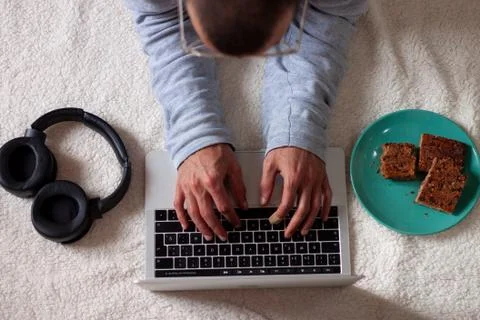 Man using computer while resting on the floor against white background Stock Photos