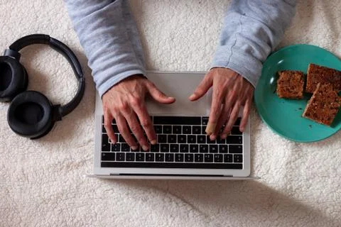 Man using computer while resting on the floor against white background Stock Photos
