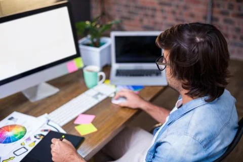 Man using computer while sitting on chair in creative office Foto stock