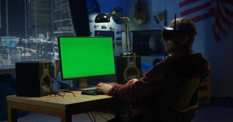 Man using a computer while wearing VR headset Stock Photos