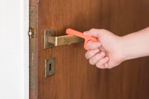 Man using a contactless tool to open a door, to avoid the spread of the Covid Stock Photos