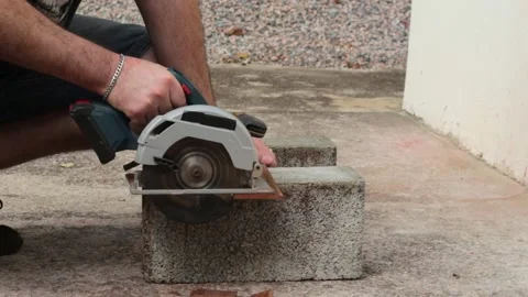 Man using a cordless circular saw to cut a piece of reclaimed wood. Video stock 321887613