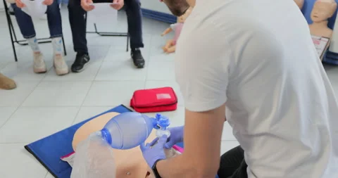 Man using CPR technique on dummy in first aid class. Oxigen mask on medical doll Stock Footage 163971521