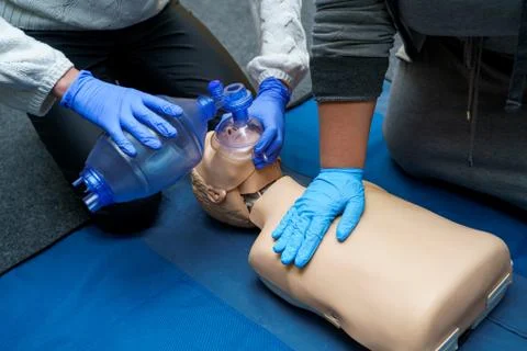 Man using CPR technique on dummy in first aid class. Oxigen mask on medical d Foto stock
