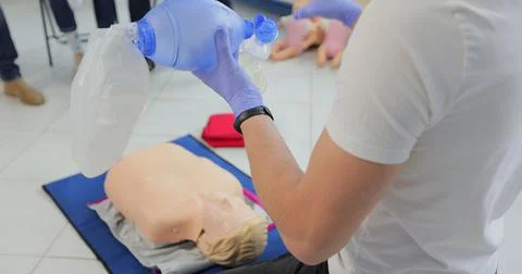 Man using CPR technique on dummy in first aid class. Oxigen mask on medical doll Foto stock