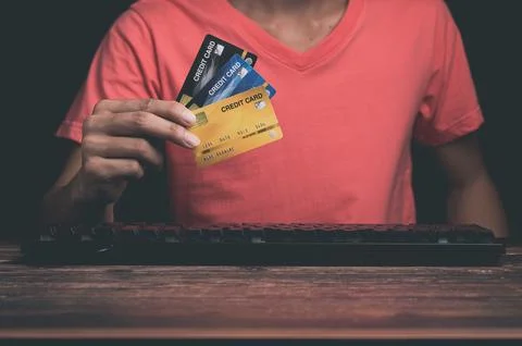 A man is using a credit card Through computer Stock Photos