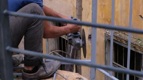 A man using a cutoff steel saw to cut a steel balcony railing - Slow motion Stock Footage 232381694