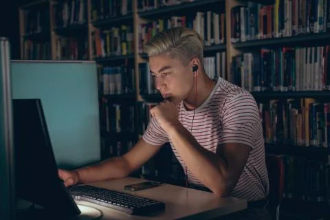 Man using desktop pc while listening music on headphones 스톡 사진