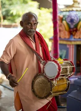 A man using dholak drums in the temple during morning pooja ritual Stock Photos