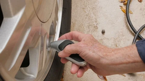 Man using digital air pressure gauge to check car tire air pressure. Stock Footage 119448191