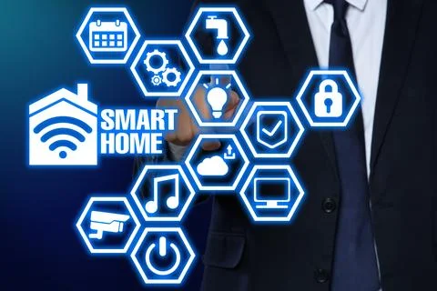 Man using digital screen with Smart Home interface on dark blue background,.. Stock Photos